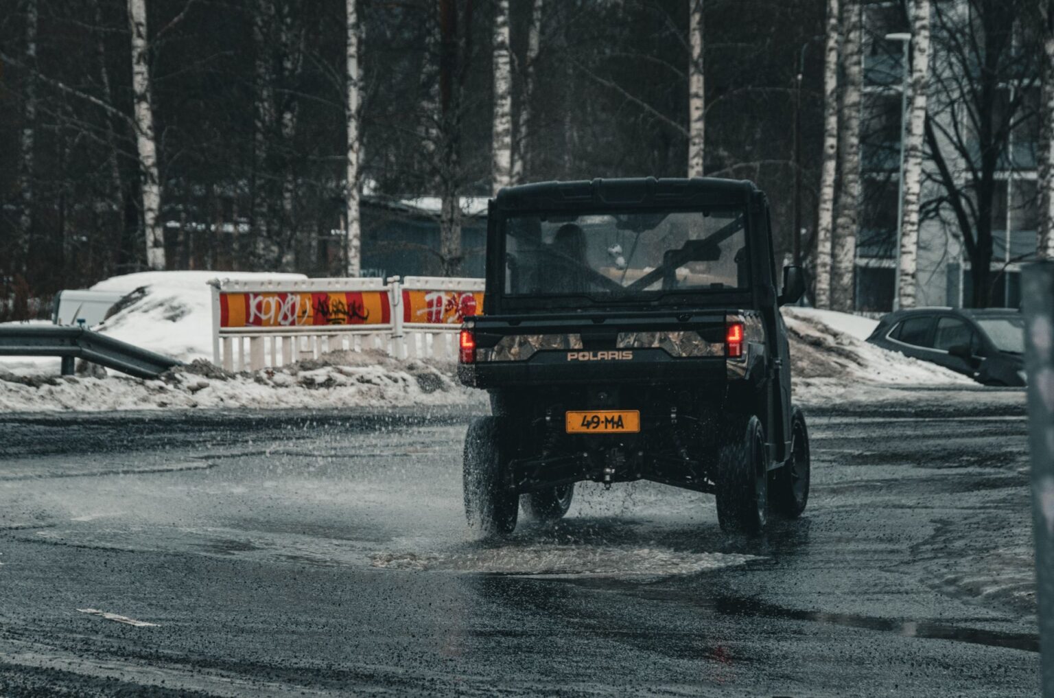 Vehicle navigating snowy and wet city streets in Finland during winter.