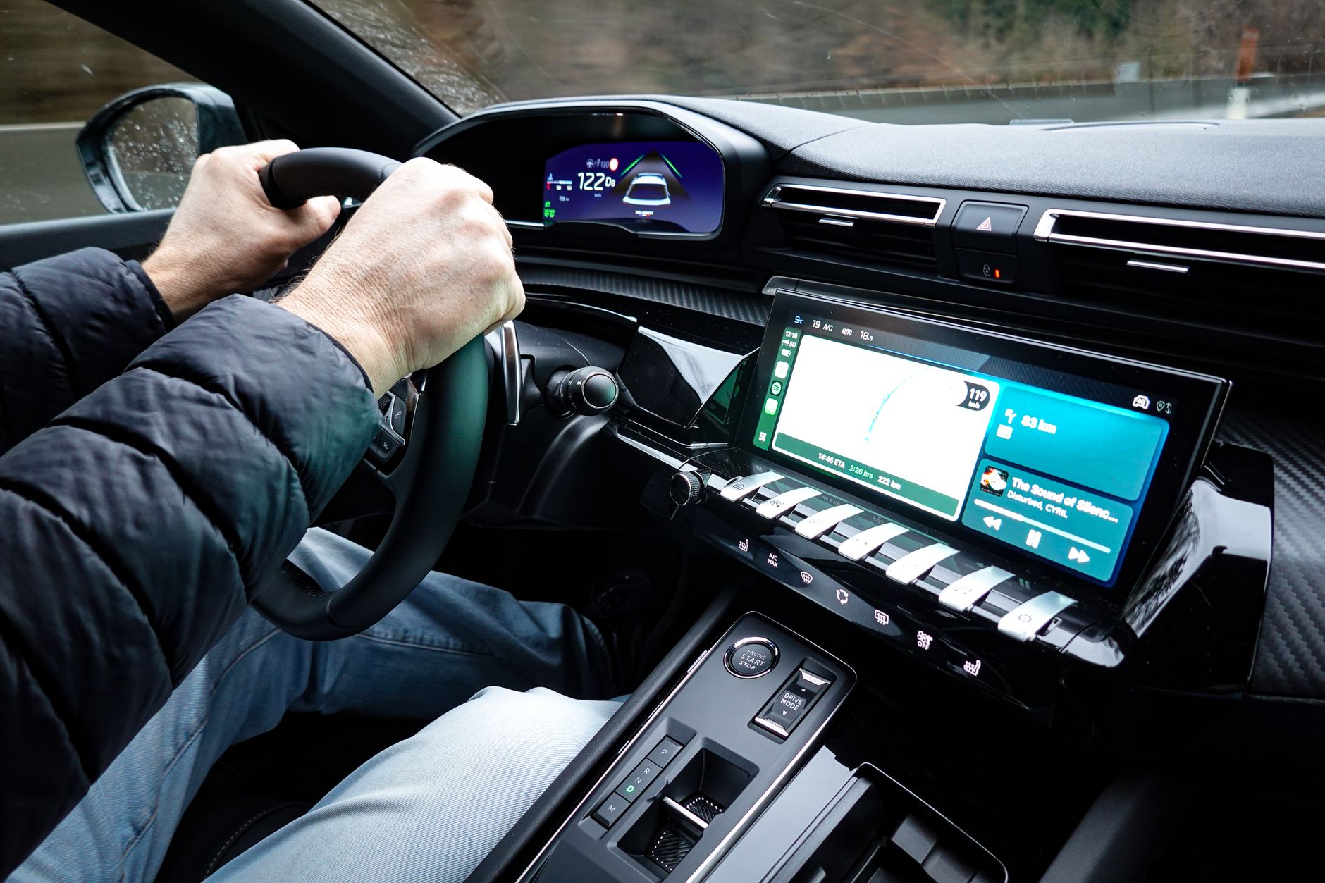 A detailed view of a car's interior with hands on the steering wheel.
