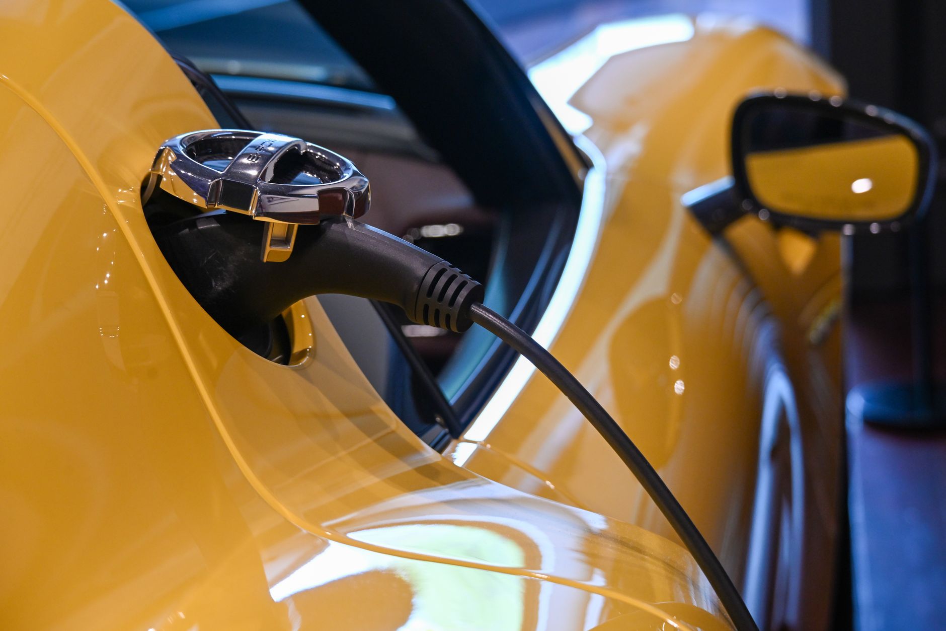 Close-up of an electric vehicle charging with a plugged-in cable.