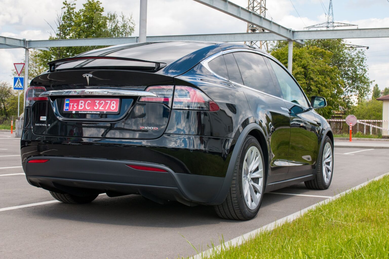 Rear view of a Tesla Model X parked outdoors on a sunny day.