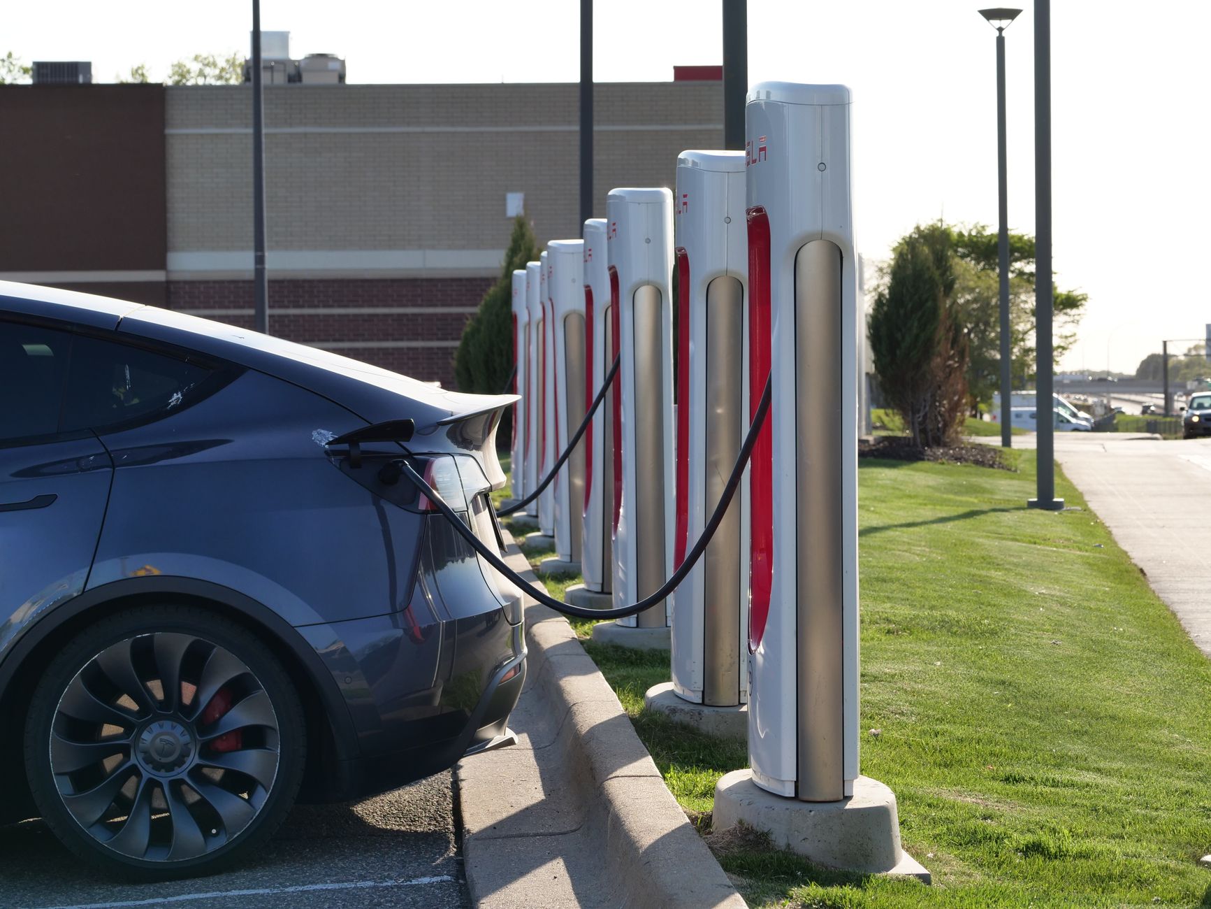 Electric car plugged into a row of charging stations