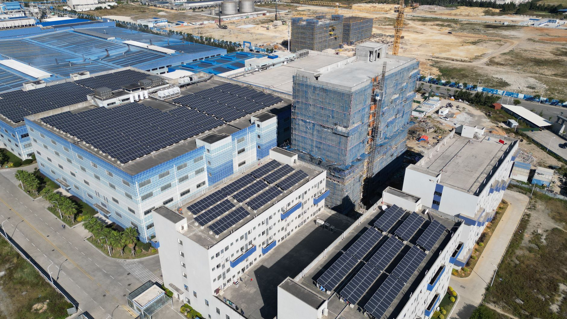 Aerial shot of industrial buildings with solar panels showcases sustainable energy.