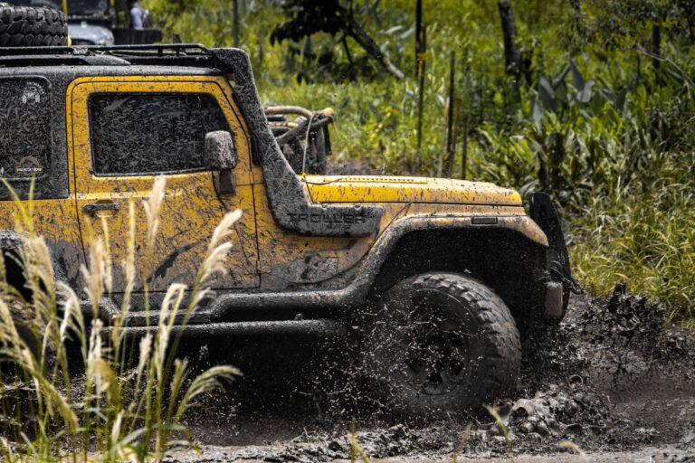 Vehicle driving through muddy off-road terrain