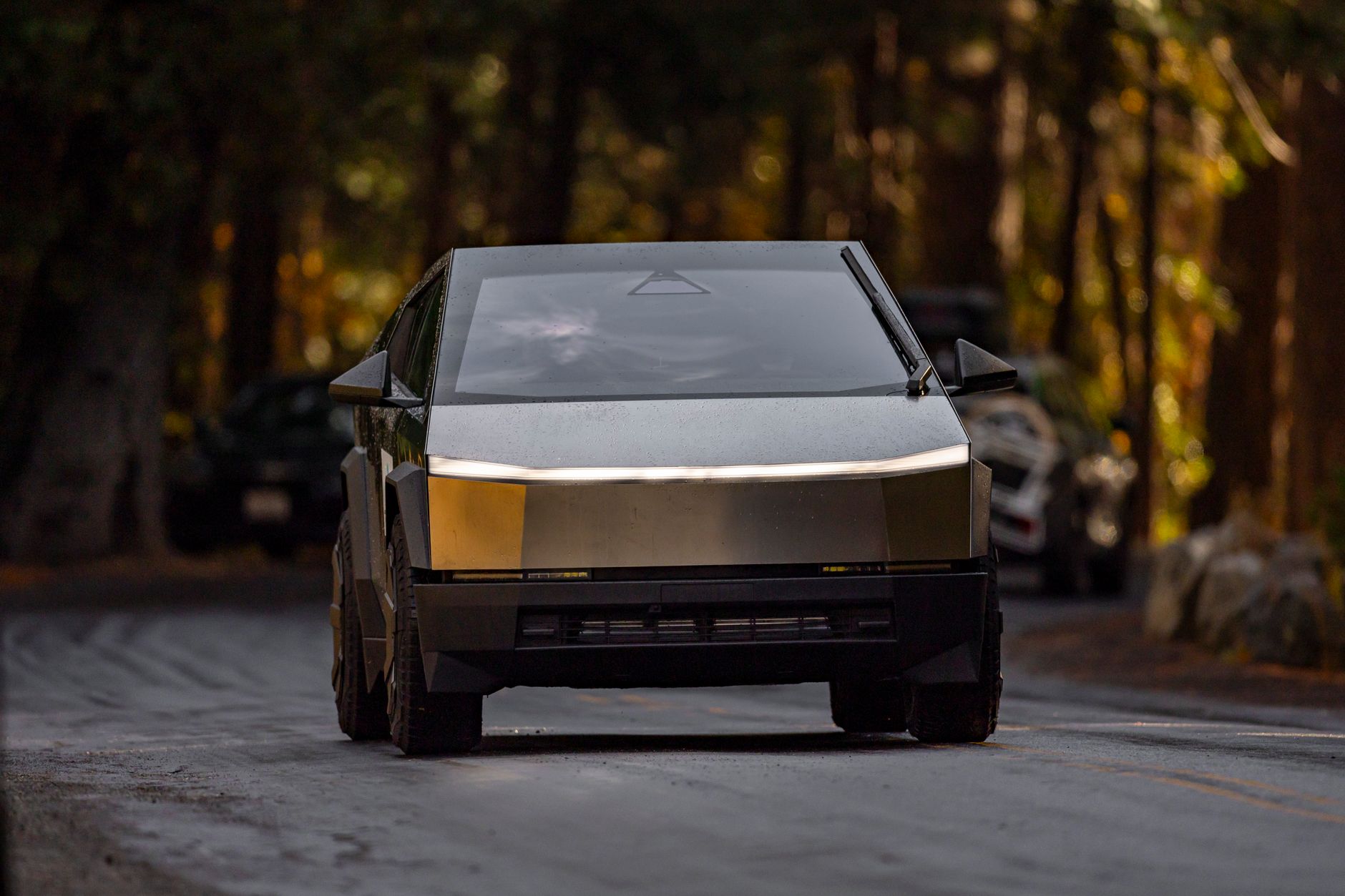 Sleek electric truck driving through a tranquil forest setting with modern design.