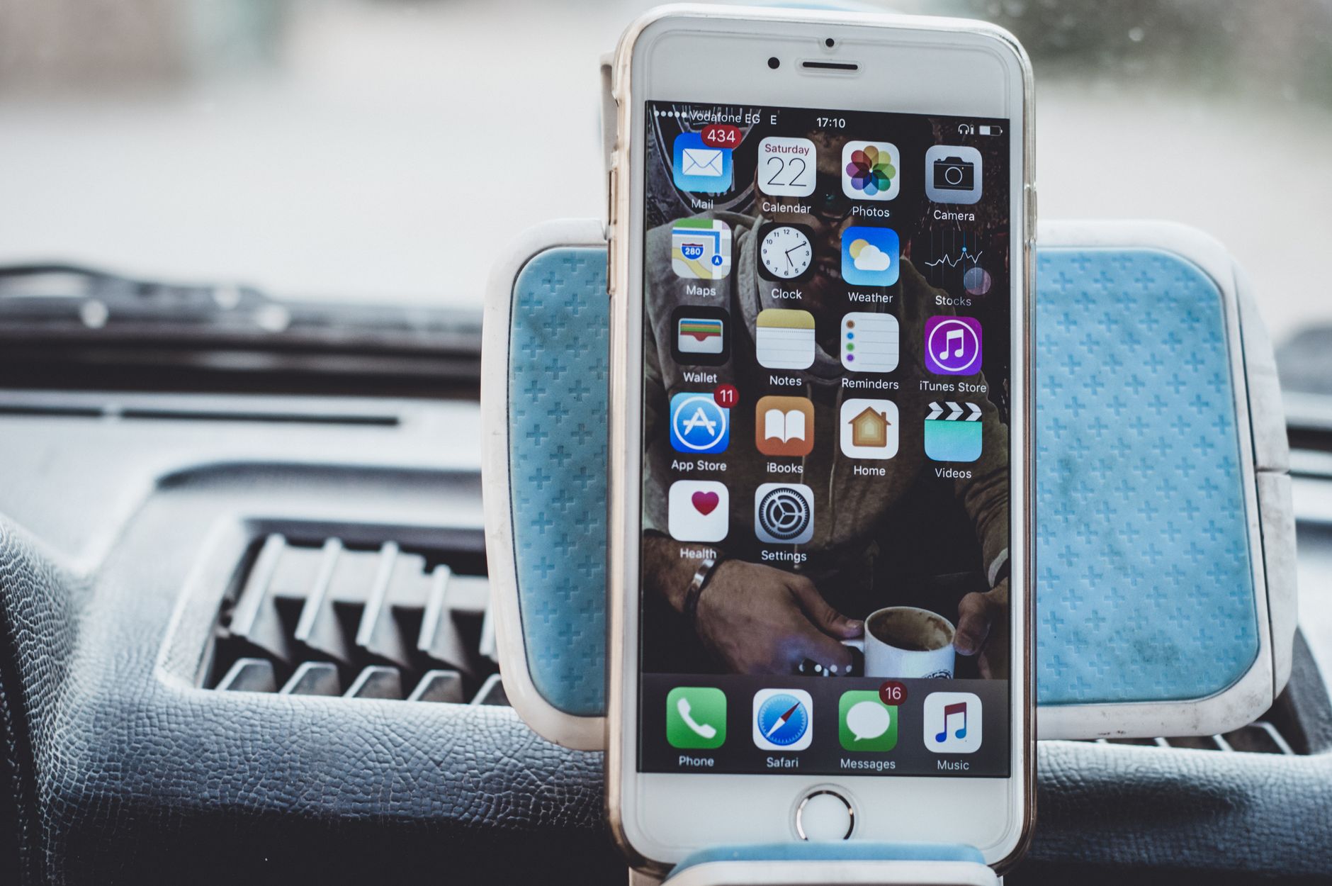 Smartphone mounted on a car dashboard showing apps