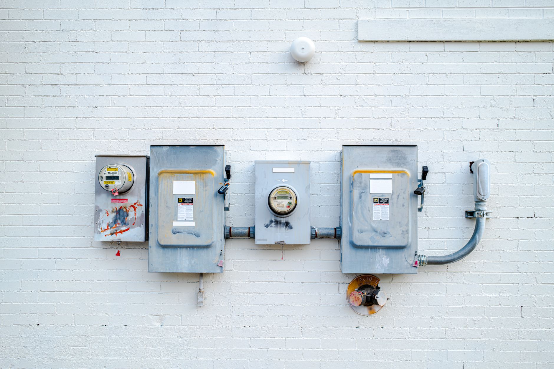 Electrical boxes and power meters mounted on a wall.
