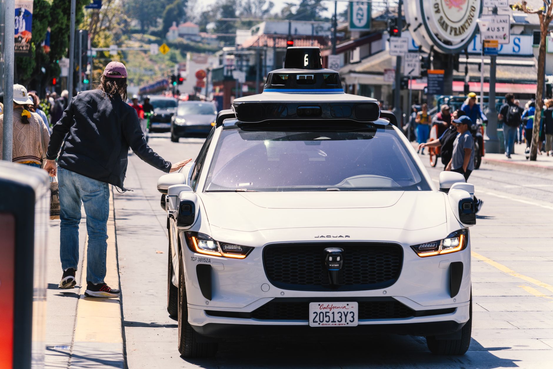 A self-driving car navigates through a bustling city street