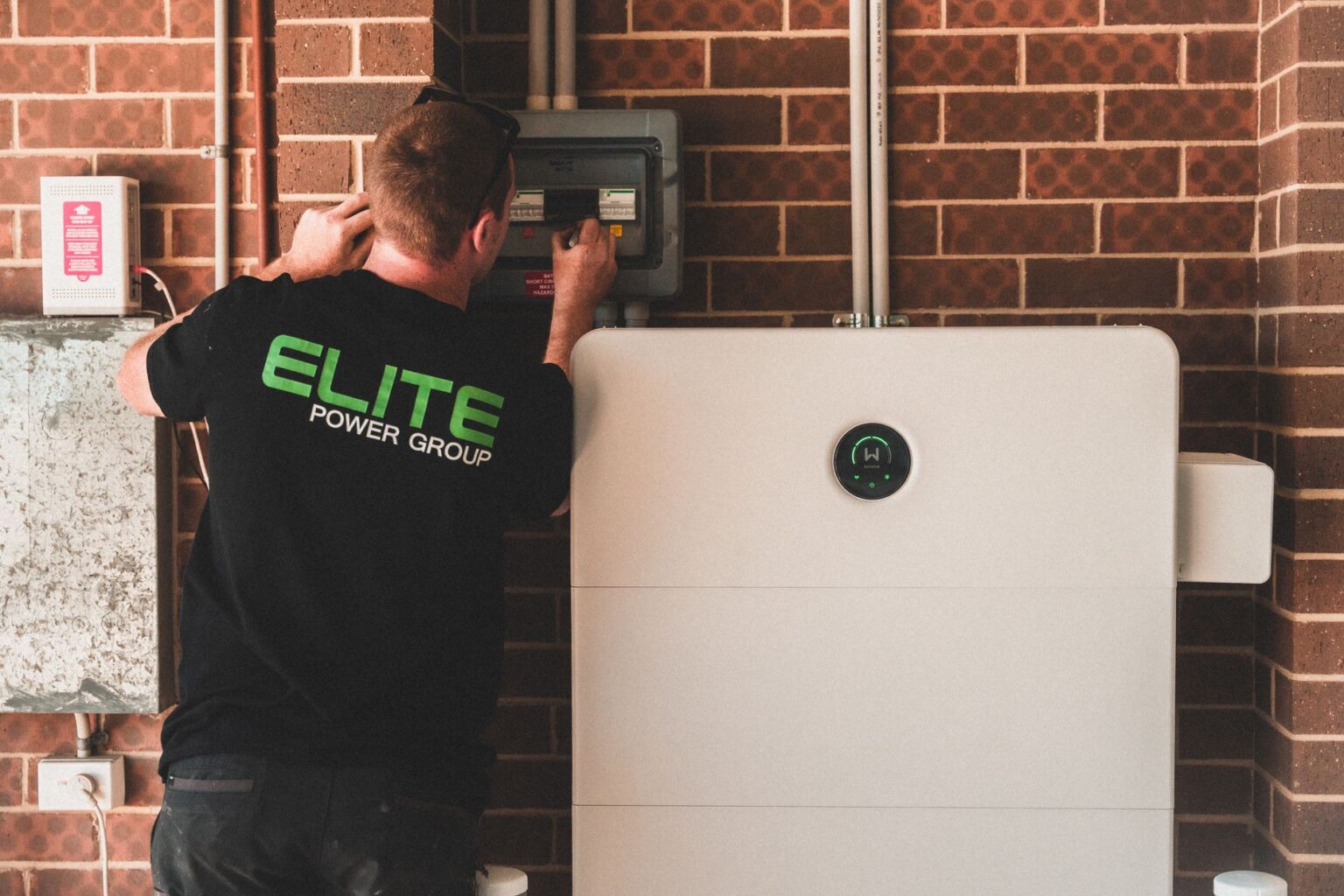 Electrician installing a home energy battery storage unit