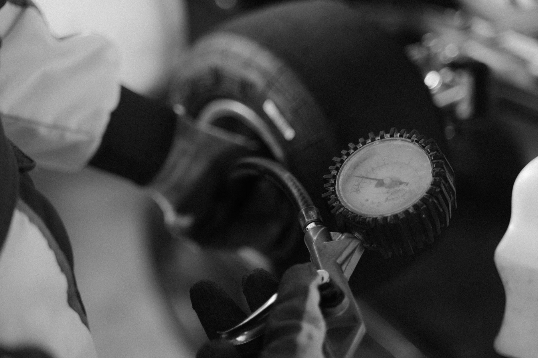 Mechanic using a gauge to check tire pressure