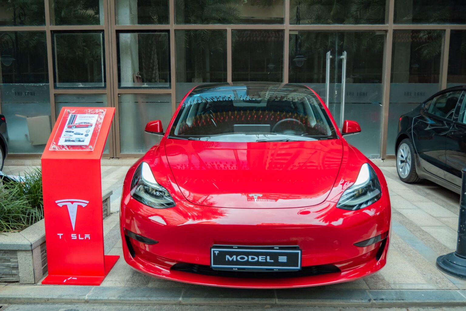 Red Tesla Model 3 parked in an urban area