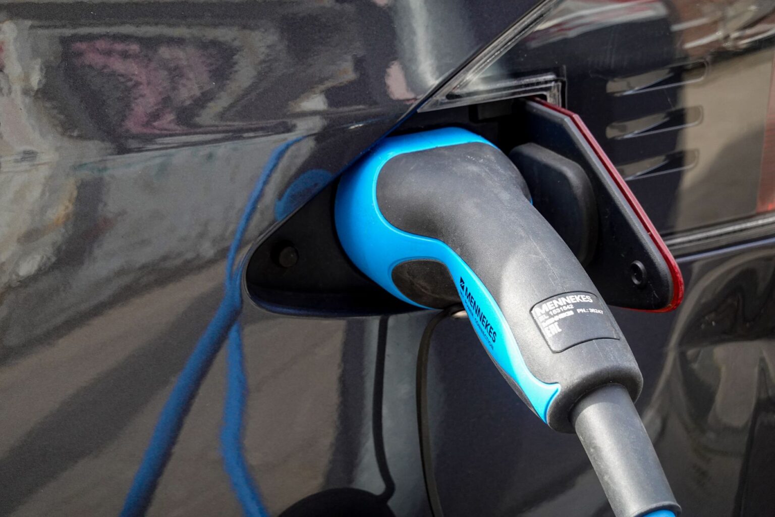 Electric vehicle charging connector plugged into a car